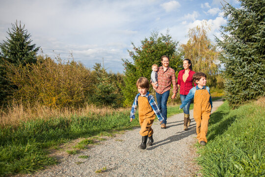 Young family of five walking together on a rural path