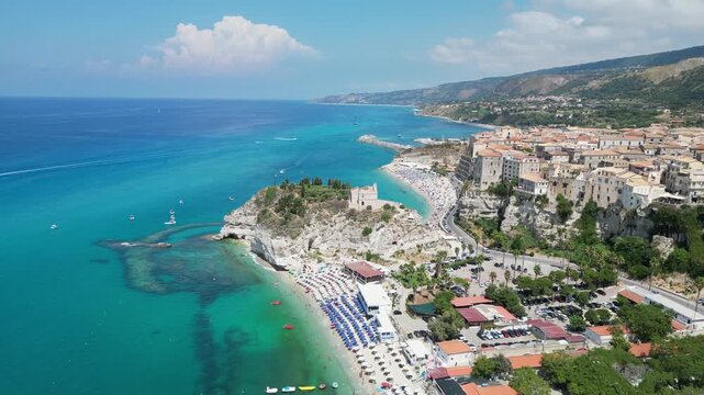 Aerial drone shot of Tropea coastline featuring Santa Maria dell Isola monastery and turquoise sea in Calabria Italy.