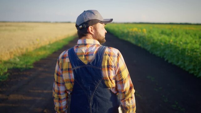 Seasoned farmer stands confidently amidst golden fields, straw hat on head. Classic red plaid shirt and sturdy overall, symbol of hard work and rural integrity, agricultural innovation and traditions