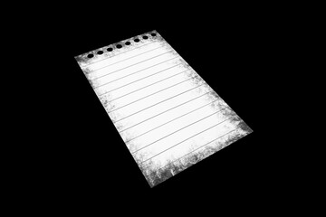 Notebook paper page isolated on black JPEG background, lying on a shelf. © vovan
