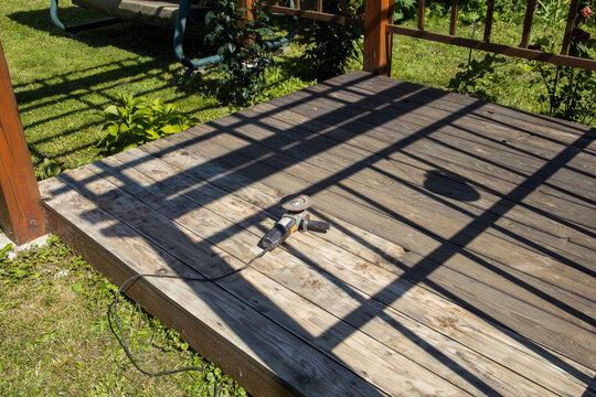 Wooden deck bathed in sunlight with shadow patterns