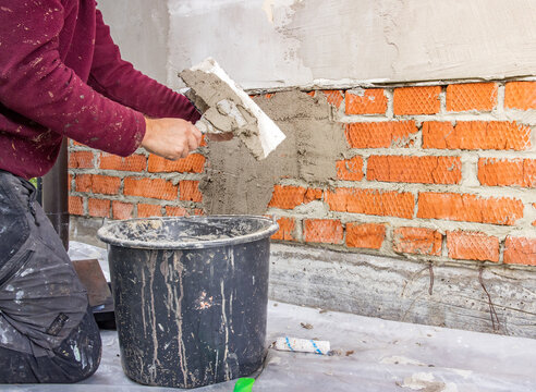Close-up of construction worker laying bricks