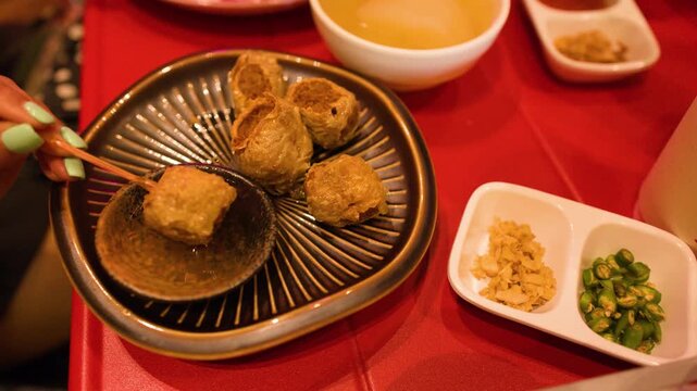 Dipping Fried Meatballs into Sweet Chili Sauce in Bangkok