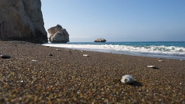 Aphrodite Rock sea stacks rising from the Mediterranean waters by a pebble beach in Cyprus