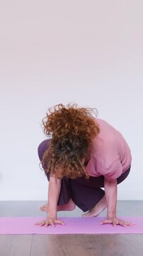 Mature woman practicing side crow yoga pose