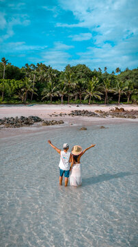 Couple tourist stay happy moment at the edge of the sea beach under shallow of the crystal clear water in summer trip on tropical island island