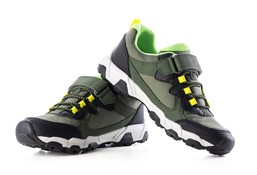 Pair of green and black kids hiking sneakers isolated on white background