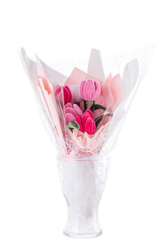 Handmade pipe cleaner tulip bouquet wrapped in pink paper in glass vase isolated on white background