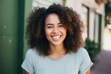 Fototapeta premium Young mixed race woman smiling broadly looking at camera with curly hair