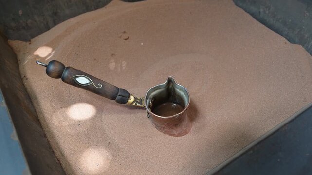 Marrakech, morocco. August 8, 2026. Traditional coffee preparation in a moroccan souk. A barista brews the aromatic beverage in a copper cezve heated by hot sand in marrakesh