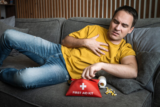 Man experiencing chest pain and urgently searching for medication in a medicine cabinet, illustrating cardiac symptoms, health anxiety, and a potential medical emergency.