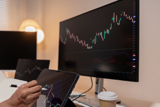 Professional stock trader reviewing market charts with sticky notes across multiple monitors, laptop, and tablet to analyze price trends, plan trading strategies, and manage investment decisions.