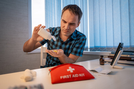 First aid kit, a set of various medicines collected in a red bag, pills for pain, an elastic bandage, a man holds a first-aid kit in his hands, hiking equipment.