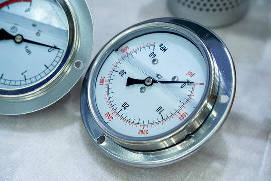 Two Industrial Pressure Gauges with Dual Scale Markings