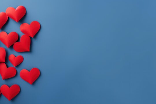 Red paper hearts forming a border, symbolizing love and romance on a blue background