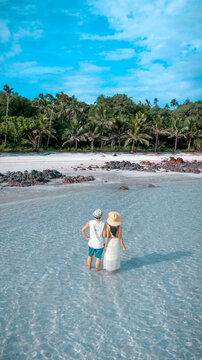 Couple tourist stay happy moment at the edge of the sea beach under shallow of the crystal clear water in summer trip on tropical island island