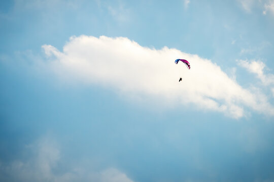 Sportsman flying with motorglider through dark clouds enjoying adrenaline