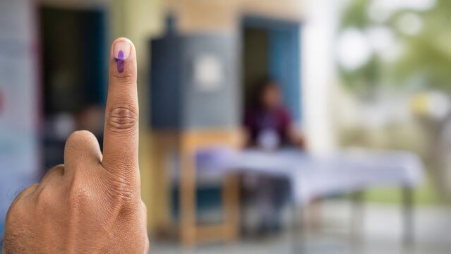 A close-up of an Indian voter's finger showing the purple indelible ink mark after casting a vote during a parliamentary election, symbolizing democracy, civic duty, and citizen participation.