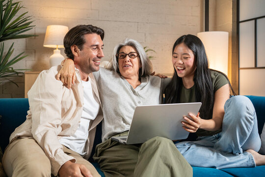 Multi-generational family enjoying leisure time together at home using a laptop