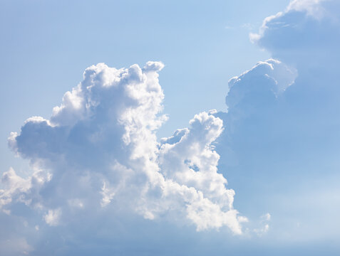 Soft white clouds drift against a clear blue sky