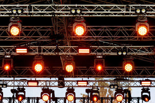 Stage lights illuminate a complex metal truss structure