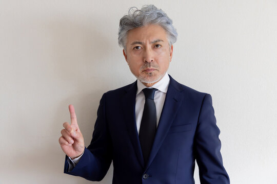 指を立てて重要なポイントを示すシニアビジネスマン
