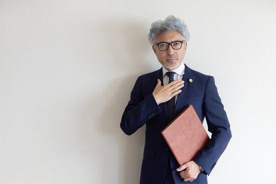 書類ファイルを抱え胸に手を当てる弁護士のポートレート
