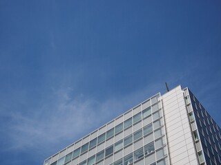Fototapeta premium 青空の余白が広がる高層ビルの静かな都市風景