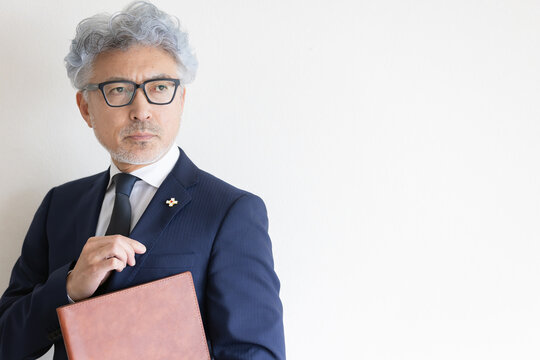 書類を抱えて遠くを見つめる検察官のポートレート
