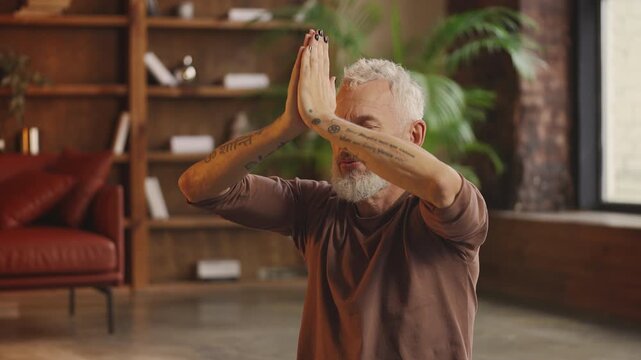 Mature fitness blogger records social media video while teaching yoga pose