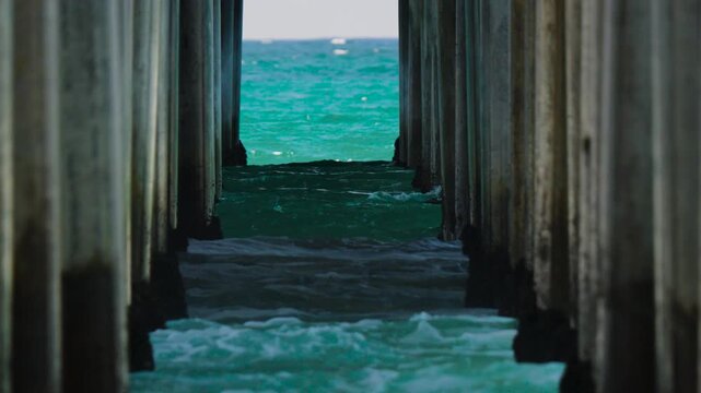 slow motion waves crashing on the pier pylons and barnacles