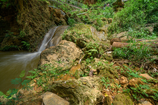 Scenic Namtok Gorge Waterfall Surrounded by Lush Greenery