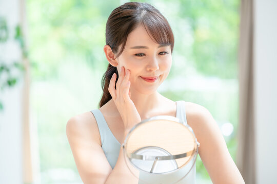 美容イメージ　スキンケア　お肌をチェックする日本人女性