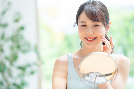 美容イメージ　スキンケア　お肌をチェックする日本人女性