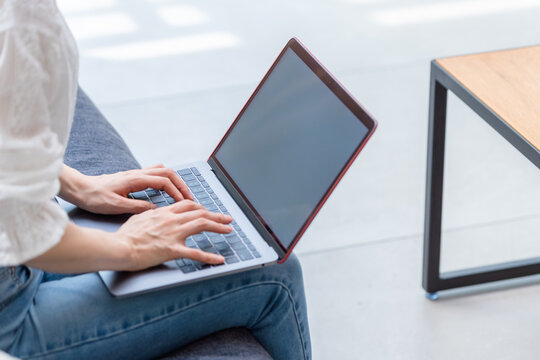 A woman using a laptop in the living room.