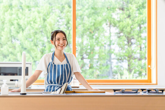 キッチンに立つ女性。料理、家事、笑顔、栄養士、カフェ、食事、調理師、家事代行、レシピ、献立、主婦