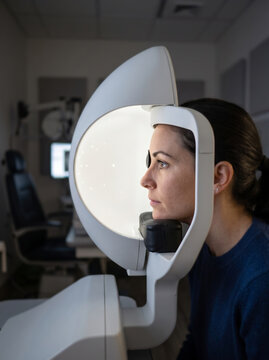 Woman Patient Undergoing Automated Visual Field Test In Ophthalmology Clinic