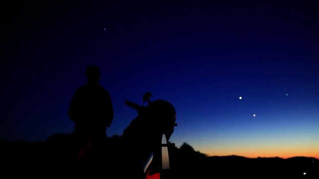 Amateur astronomer observing stars, planets, Moon and other celestial objects with a telescope in nature.