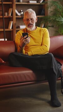 Fashionable middle-aged man has phone video call, talking with his family
