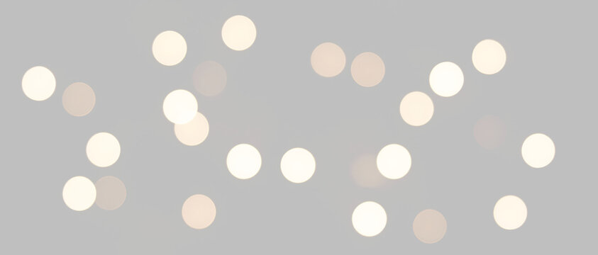 Glowing white golden bokeh lights. Luminous glitter particle overlay on transparent background. Magical festive holiday border for compositing