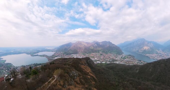 Monte Barro peak overlooking Lake Annone, Lecco, and mountains in Lombardy, Italy. Aerial drone orbiting
