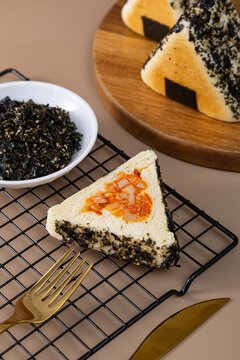 Triangle shaped savory bread stuffed with savory filling and seaweed topping