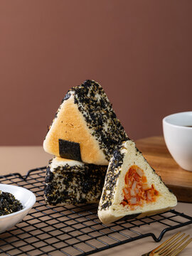 Triangular stuffed buns topped with nori and sesame seeds