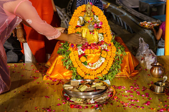 India. State of Uttar Pradesh. Varanasi. A devotee places her hand in blessing on a statuette of the goddess Ganga (or Lakshmi) during the Ganga Aarti ceremony