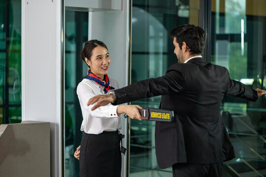 Airline ground staff using metal scanner for security check every passenger in the airport departure terminal for safety protocol before boarding to plane