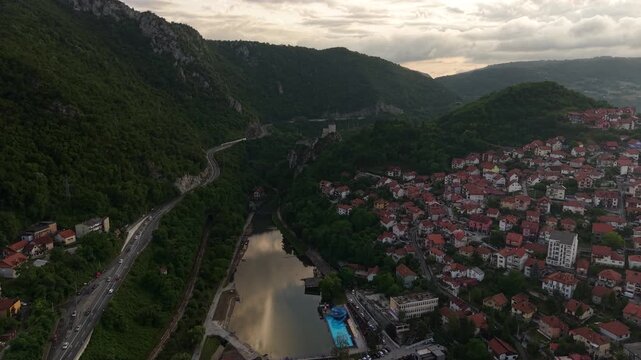 Drone Shot of Uzice, Serbia. Djetinja River Beach, Road Traffic and Hillside Homes at Sunset