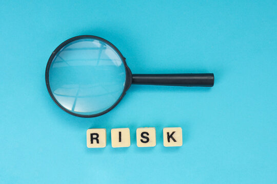 Flat Lay of Financial Investigation Tool Above Risk Blocks Against Blue Background