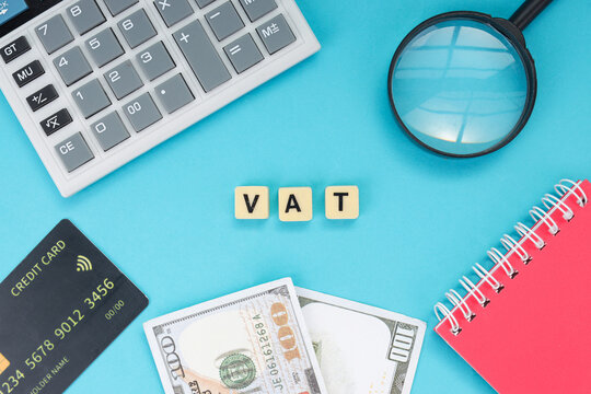 High Angle of Financial Investigation Tools and Alphabet Letter Block VAT on Blue Background