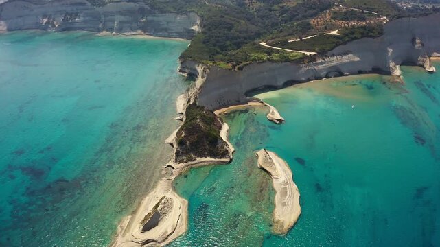 Aerial drone perspective over turquoise sea waters and white sedimentary cliffs of Corfu island Greece.