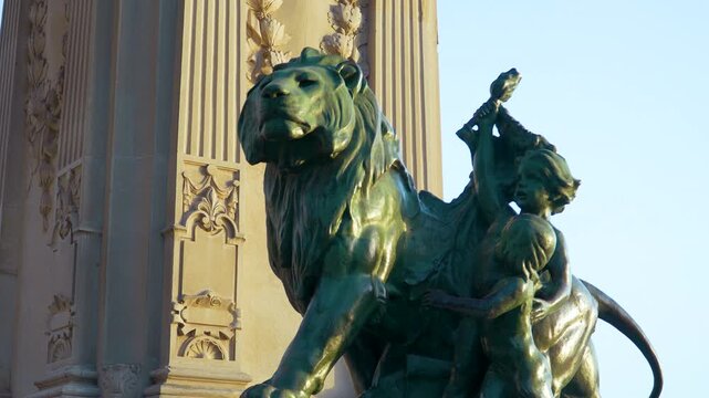 Detailed view of a bronze lion sculpture and figures at the Monument to Alfonso XII in El Retiro Park, Madrid, Spain. Authentic historical landmark during golden hour.